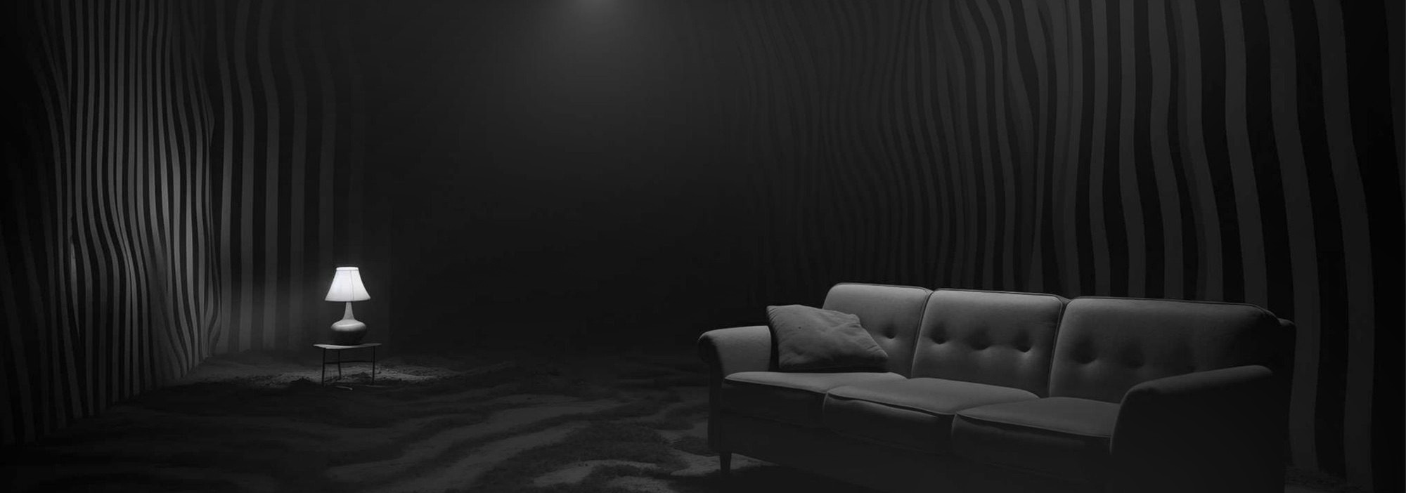 Dark retreat room with wavy sound-absorbing walls lit by a single warm lamp