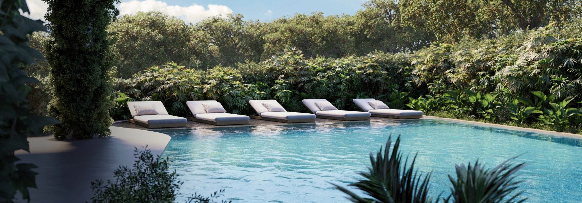 Ocean-view pool and thermal circuit set into turquoise water, surrounded by jungle